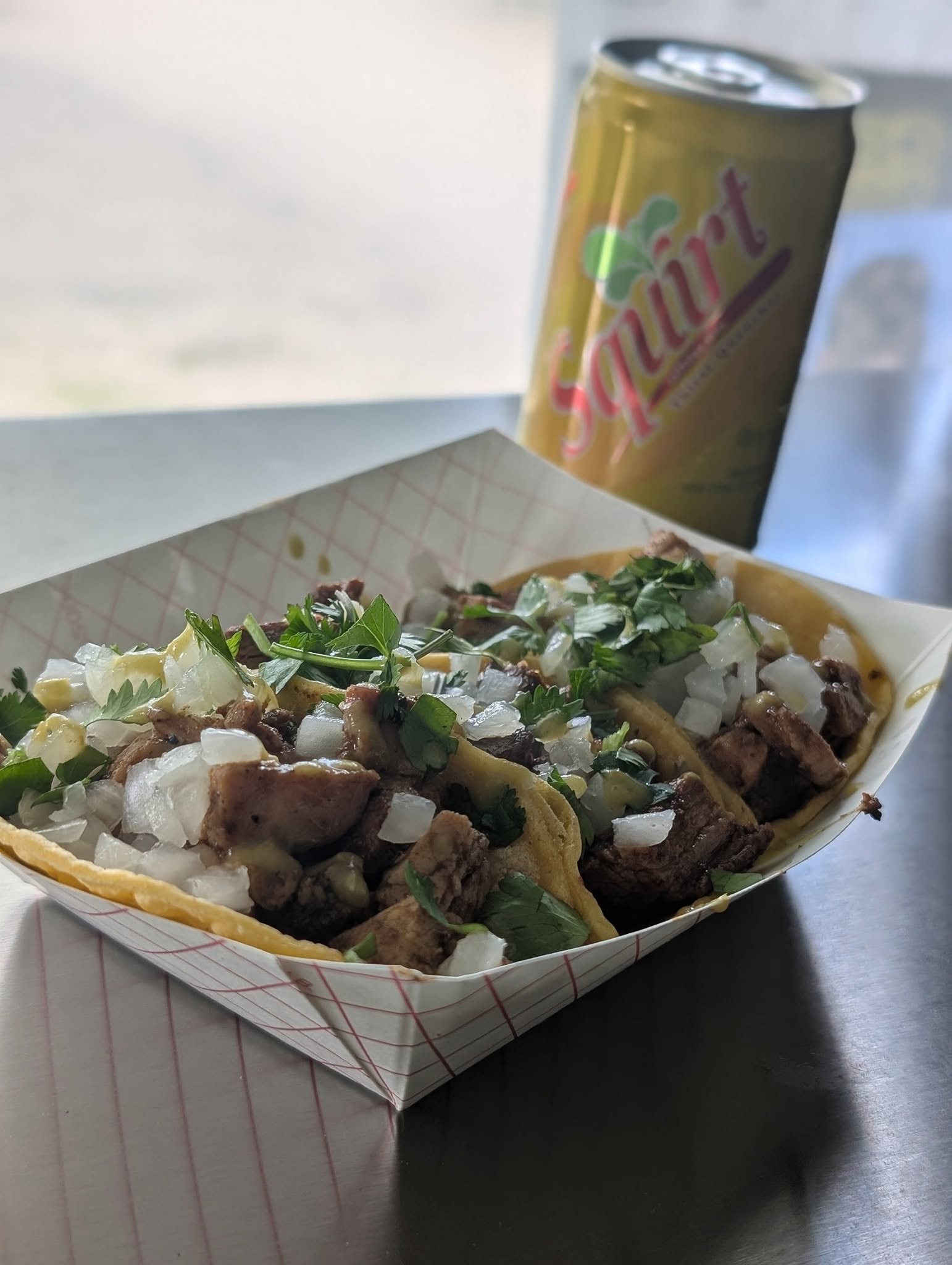 A loaded Cookin’ with Beans taco boat with a cold Squirt