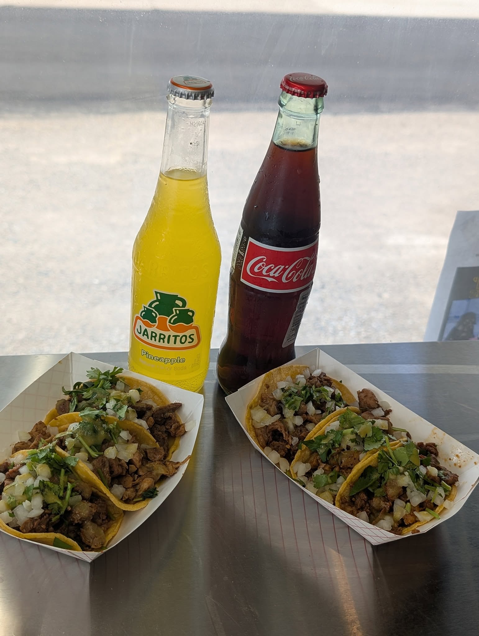 Two plates of Cookin’ with Beans street tacos with bottled drinks